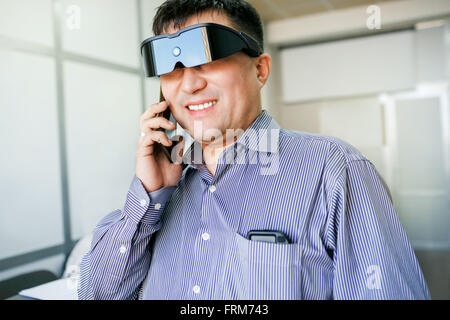 Man in virtual reality glasses talking on phone Stock Photo