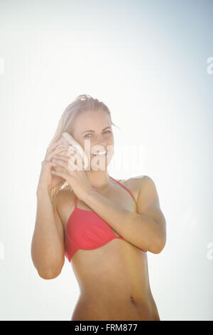 Woman listening into a seashell Stock Photo
