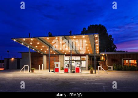 illuminated remote fuel station in Western Australia at sunset with nobody at pump filling petrol or diesel Stock Photo