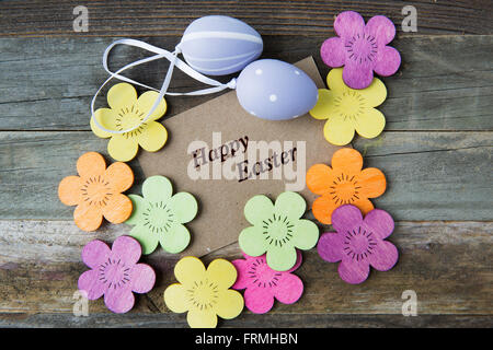 Happy Easter greeting card surrounded by Easter eggs and flowers. Stock Photo