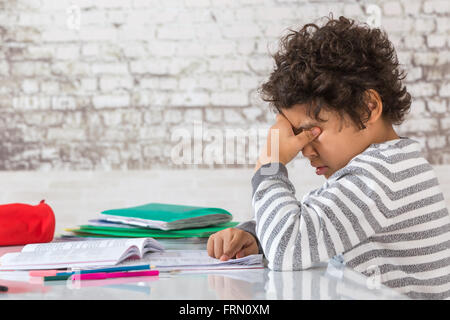 Tired Teenager doing Homework at the Home Stock Photo