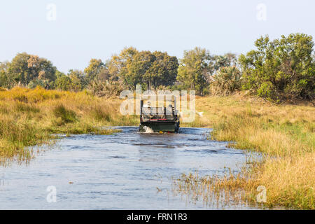 Safari 4wd jeep crossing a river ford, Sandibe Camp, by the Moremi Game Reserve, Okavango Delta, Botswana, southern Africa Stock Photo