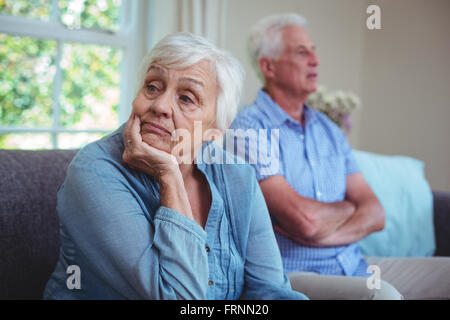 Senior couple after arguing while sitting on sofa Stock Photo