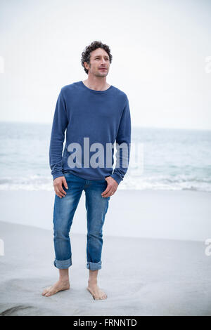 Handsome man standing at beach Stock Photo