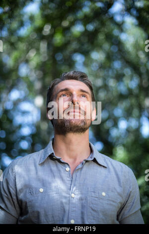 Thoughtful young man looking up Stock Photo