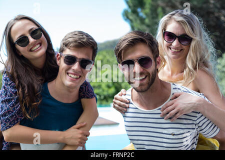 Two men giving a piggy back to women Stock Photo