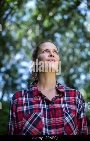 Thoughtful young woman looking up Stock Photo
