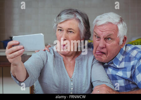 Senior couple making faces while taking selfie Stock Photo