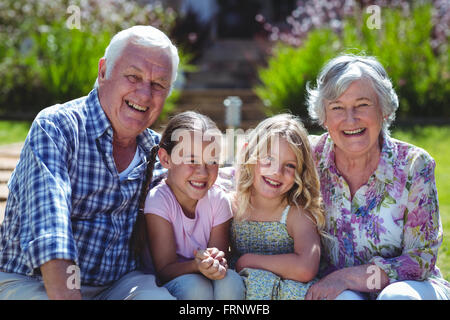 Portrait of cheerful girls with grandparents while sitting in back yard Stock Photo