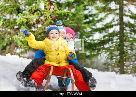 Children winter fun on sledge sliding down Stock Photo