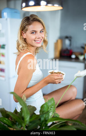 Portrait of happy young woman having breakfast in kitchen Stock Photo