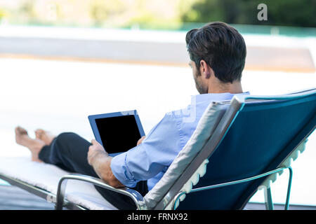 Man using digital tablet near pool Stock Photo