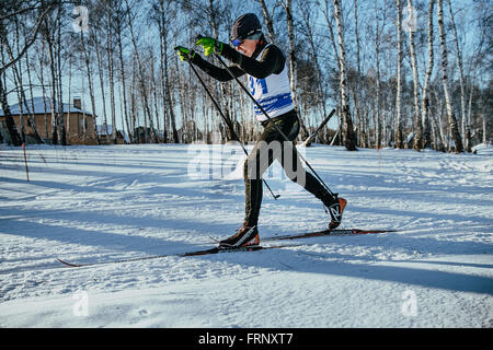 male skier middle-aged of classic style in winter woods on sports race during Championship of Chelyabinsk in cross-country skiin Stock Photo