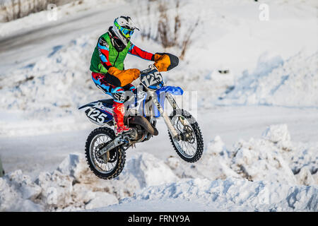 jump racer on a motorbike over snowy hill during Cup Winter motocross Stock Photo