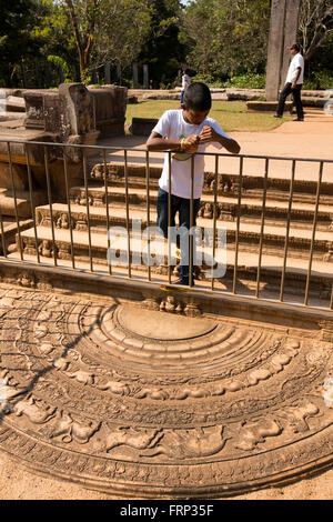 Sri Lanka, Anuradhapura, Abhayagiri Monastery, child looking at at Mahasen’s Palace Moonstone Stock Photo