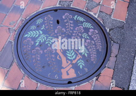 Beautiful colored manhole cover of a wysteria tree in Kurashiki City, Okayama, Japan