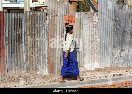 Woman carrying bricks on her head on a building site in Amarapura, Mandalay, Myanmar (Burma) Stock Photo