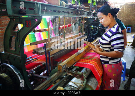 Weavers weaving yarn using looms in a workshop in Amarapura, Mandalay, Myanmar (Burma) Stock Photo