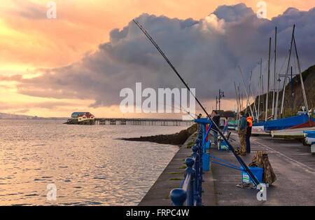 fishermen at sunset at the mumbles, wales Stock Photo