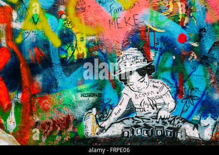 Famous place in Prague - The John Lennon Wall. Wall is filled with John Lennon inspired graffiti and lyrics from Beatles songs Stock Photo