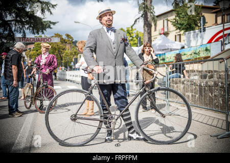 An elegant man dressed in vintage style. Eroica is a cycling event that takes place since 1997 in the province of Siena with routes that take place mostly on dirt roads with vintage bicycles. Usually it held on the first Sunday of October. Stock Photo