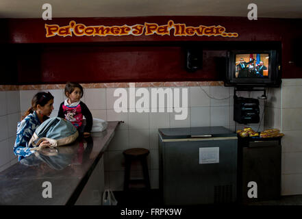 Cuban woman with child are watching Cuban leader Raul Castro greeting US President Barack Obama  in television in the central part of Havana, Cuba, March 21, 2016. Cuba hosts U.S. President Barack Obama from March 20. (CTK Photo) Stock Photo