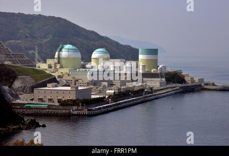 Ehime, Japan. 23rd Mar, 2016. Shikoku Electric Power Co.'s Ikata nuclear power plant reactor buildings one (R), two (C) and three (L) stand at Ikata town in Ehime prefecture, Japan's southern island of Shikoku on Wednesday, March 23, 2016. Japan's nuclear regulation authority approved to reactivate Ikata's reactor three on March 23 despite lingering safety concerns from the 2011 Fukushima nuclear accident. © Yoshio Tsunoda/AFLO/Alamy Live News Stock Photo