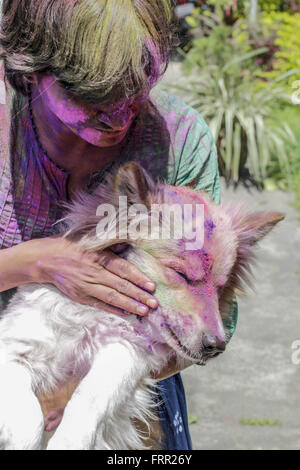 Sivasagar, Assam, India. 24th Mar, 2016. An Indian woman applies colored powder to her pet dog during celebrations of the Holi festival in the Sivasagar district of northeastern Assam state on March 24, 2016. Holi, the festival of colours, is a riotous celebration of the coming of spring and falls on the day after full moon annually in March. Revellers spray coloured powder and water on each other with great gusto, whilst adults extend the hand of peace. Credit:  Luit Chaliha/ZUMA Wire/Alamy Live News Stock Photo