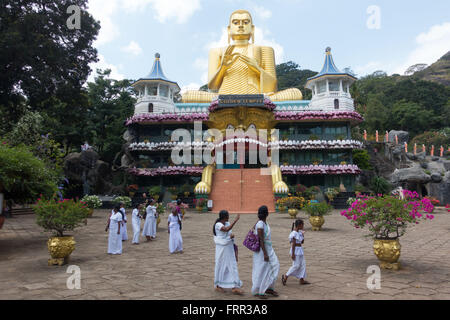 Pilgrims waving goodbye to their Lord Buddha at The Golden Temple, Dambulla, Sri Lanka Stock Photo