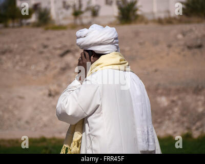 Arab man using mobile phone in the desert oasis. Stock Photo