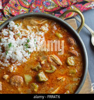 Copper pot filled with sausage gumbo and a scoop of rice. Stock Photo