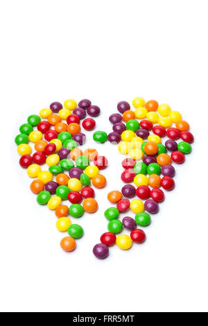 colorful candy on white background in broken heart shape Stock Photo