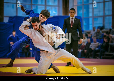 fight between young male judoists. in background referee during All-Russian competition on judo Stock Photo