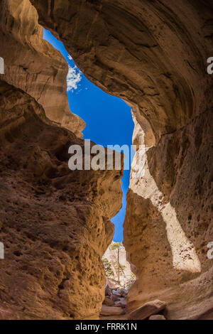 Hiking through the narrow slot canyon along the Slot Canyon Trail at Kasha-Katuwe Tent Rocks National Monument in New Mexico, US Stock Photo