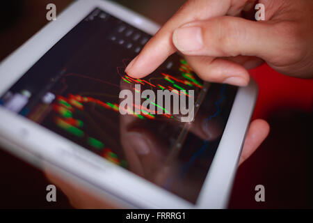 macro close up a man checking stock market on tablet, smartphone Stock Photo