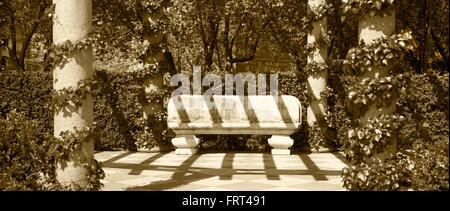 Stone bench in a park. Sepia tone. Horizontal Stock Photo