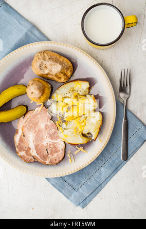 Baked potatoes with meat and pickles on the ceramic plate Stock Photo