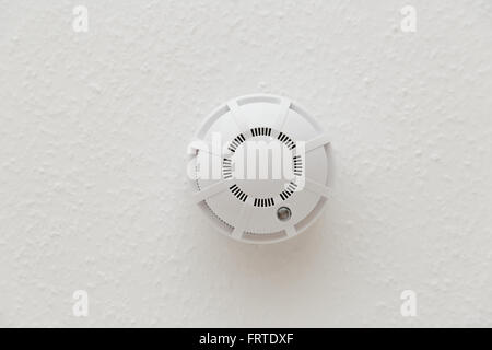 White smoke detector on ceiling in closeup