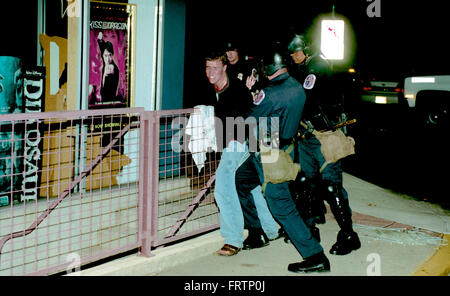 College Park, Maryland, USA, 1st April, 2002 Members of the Prince Georges County Police department in riot gear arrest one of about 17 students from the University of Maryland during a riot that broke out after The University of Maryland defeated Indiana to claim title to the NCAA men's basketball championship. It was Maryland's first ever college basketball title and the victory sent fans into a frenzy. An estimated 5,000 hit the streets in celebration. Fueled by excessive alcohol consumption, the mob lit trash cans and couches on fire in the streets. Credit: Mark Reinstein Stock Photo