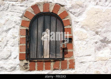 Virgin Mary locked behind bars and padlock. Stock Photo