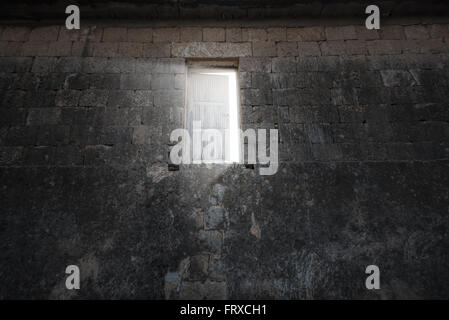 Abstract dark concrete interior with glowing doorway and light coming in. Stock Photo