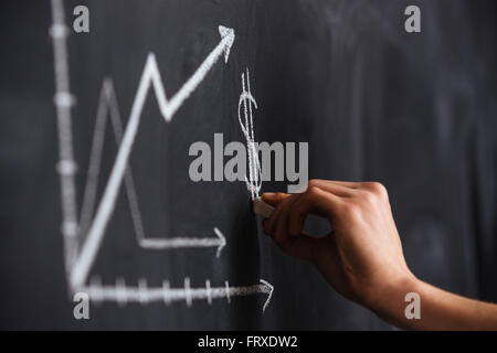 Increasing graph of currency rate drawn by hand on blackboard with chalk Stock Photo