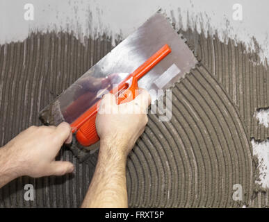 Worker tiler put cement on the wall Stock Photo