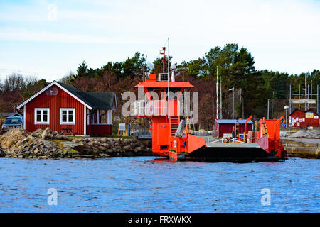 Torhamn, Sweden - March 18, 2016: The bright orange cable operated car ferry between mainland and the Ytteron island. Here seen Stock Photo