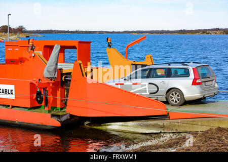 Torhamn, Sweden - March 18, 2016: The bright orange cable operated car ferry between mainland and the Ytteron island. Here seen Stock Photo
