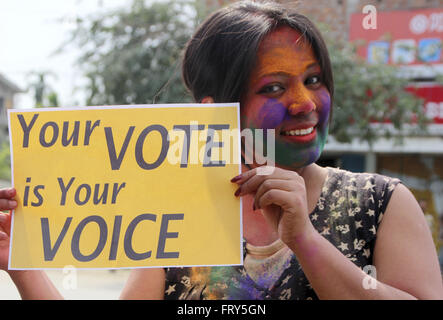 Sivasagar, Assam, India. 24th Mar, 2016. An Indian girl pose with playcards and urge people to come out and vote as they celebrates holi, the festival of colors in Sivasagar district of north-eastern state of Assam on March 24, 2016. Thousands of Indian voters will elect legislators for the 126 seats contested in 25,000 polling stations in Assam state in two phases on April 4th and 11th. Credit:  Luit Chaliha/ZUMA Wire/Alamy Live News Stock Photo