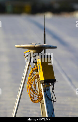 External GPS receiver used in Burscough, Lancashire, UK 25th March, 2016.  UK Weather.  A landscape being covered in white fleece as farmers use Trimble GPS tractor satellite guidance systems equipment to plot their fields and plant this seasons’ lettuce seedlings. Horticultural fleece is a thin, unwoven, polypropylene fabric that is used as a floating mulch to protect both early and late crops and other delicate plants from cold weather and frost, as well as insect pests during the normal growing season. Stock Photo