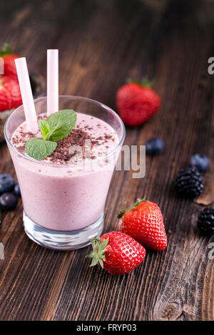 Tasty strawberry shake on wooden table with fruits Stock Photo