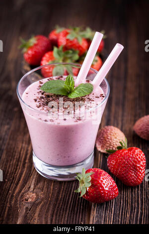 Tasty strawberry shake on wooden table with fruits Stock Photo