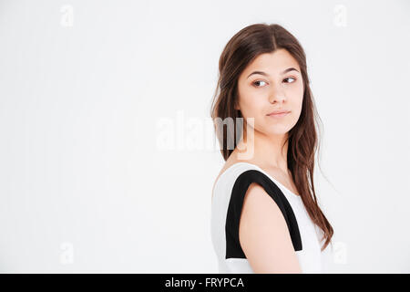 Closeup of serious young woman looking away over white background Stock Photo